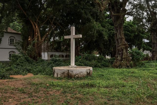 General view of a cross situated on the Roça Sundy, near Santo Antonio, in Príncipe Island in São Tomé and Príncipe, on  August 1, 2026. Located on Príncipe island, Roça Sundy is famous both for its cocoa production and the historical site where Arthur Eddington conducted observations proving Einstein's theory of general relativity. It is one of six roças recognized as UNESCO World Heritage sites. The Roças are historic agricultural plantations in São Tomé and Príncipe that were established by the Portuguese in the 19th and 20th centuries for coffee and cocoa production. Operating as self-sufficient, hierarchical complexes, they included processing factories, housing (sanzalas), hospitals, and railways. (Photo by Daniel BELOUMOU OLOMO / AFP)