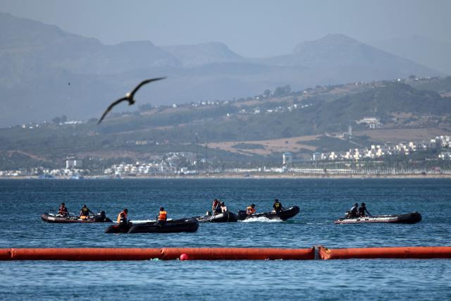 People aboard inflatable boats navigate on the Moroccan side of the new floating barrier deployed by Spain to reinforce security near the border post of the Spanish enclave of Ceuta on August 2, 2026. At least 72 people died during last week's mass influx of migrants into Spain's Ceuta enclave, when tens of thousands of people mostly swam around the border post from Morocco, local officials said today. Most of the estimated 60,000 people who rushed into Spain's north African territory have returned to Morocco since the territory's largest mass migrant crossing. (Photo by Henry Nicholls / AFP)