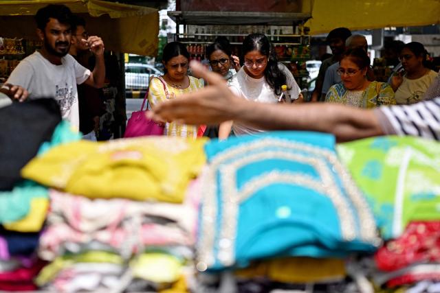 A vendor attends to customers at his shop in a marketplace in New Delhi on August 2, 2026. (Photo by Sajjad HUSSAIN / AFP)