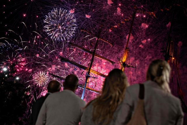Spectators watch the closing fireworks for The Tall Ships Races 2026 as they illuminate the night sky over the port of Aalborg, Denmark on August 1, 2026. 51 sailing ships visit the Aalborg and Noerresundby waterfronts from July 30 - August 2, 2026. (Photo by Henning Bagger / Ritzau Scanpix / AFP) / Denmark OUT