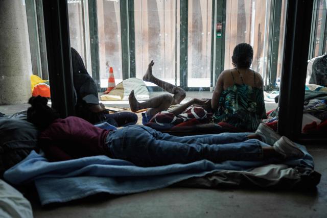 People rest inside the Samusocial headquarters, occupied by families and people waiting for emergency accommodation, in Paris, on August 1, 2026. The CGT union branch of the Paris Samusocial announced the continuation of a strike launched on June 23, in its sixth week, protesting against what it described as "the return of too many families to the streets". Utopia 56, an association that supports migrants and homeless people, has been occupying the forecourt of the Samu social headquarters in Paris for a week in support of the families. “There are nearly 200 people” on site, waiting for housing, according to the CGT. (Photo by Simon WOHLFAHRT / AFP)