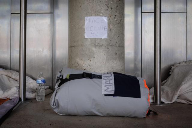 This photograph shows a placard reading "spot occupied please" inside the Samusocial headquarters, occupied by families and people waiting for emergency accommodation, in Paris, on August 1, 2026. The CGT union branch of the Paris Samusocial announced the continuation of a strike launched on June 23, in its sixth week, protesting against what it described as "the return of too many families to the streets". Utopia 56, an association that supports migrants and homeless people, has been occupying the forecourt of the Samu social headquarters in Paris for a week in support of the families. “There are nearly 200 people” on site, waiting for housing, according to the CGT. (Photo by Simon WOHLFAHRT / AFP)