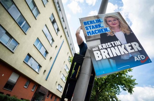 An activist of far-right Alternative fuer Deutschland (Alternative for Germany - AfD) puts up an election poster featuring a portrait of the AfD's main candidate Kristin Brinker in the upcoming regional elections in Berlin on August 2, 2026. Berlin goes to the polls on September 20, 2026. (Photo by John MACDOUGALL / AFP)