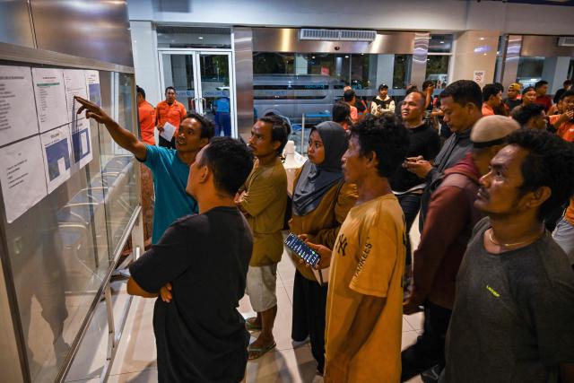 Family members and relatives wait for updates on the search and rescue operation after the passenger ship Mutiara Sentosa 2 caught fire off Madura island, East Java, at Tanjung Perak port in Surabaya on August 2, 2026. Five people have been found dead, 41 are missing and 225 were rescued after an Indonesian ferry caught fire while at sea on August 2, search and rescue officials said. (Photo by JUNI KRISWANTO / AFP)