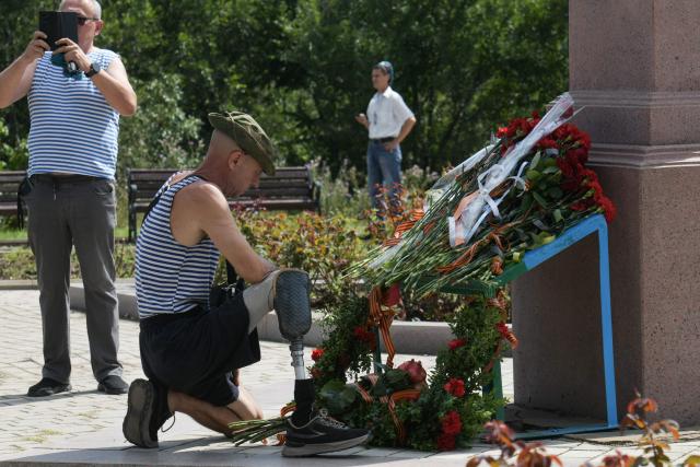 An amputee veteran lays flowers at the monument to Vasily Margelov, Commander of the Soviet Airborne Forces, during Paratroopers' Day celebrations in Donetsk, Russian-controlled Ukraine on August 2, 2026, amid the ongoing Russian-Ukrainian conflict. (Photo by AFP)