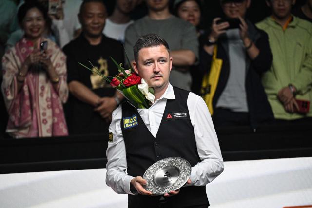 Runner-up England's Kyren Wilson poses for photographs with his trophy after losing to England's Judd Trump in the final of the Shanghai Masters snooker tournament in Shanghai on August 2, 2026. (Photo by Jade GAO / AFP)