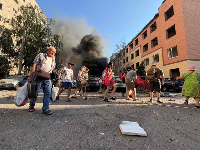 People walk away in front of heavy smoke rising at the site of a Russian airstrike in Zaporizhzhia on August 2, 2026, amid the Russian invasion of Ukraine. (Photo by Darya NAZAROVA / AFP)