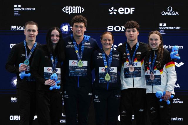 LtoR, Second placed, Neutral Athletes diver Ilia Molchanov and Neutral Athletes diver Elizaveta Kuzina winners, Italy's diver Matteo Santoro and Italy's diver Chiara Pellacani and third placed Germany's diver Luis Carlo Avila Sanchez and Germany's diver Lena Corona Hentschel celebrate on the podium after the mixed 3m synchro diving final event during the LEN European Aquatics Championships, at the Olympic Aquatics Centre in Saint-Denis, northeastern suburbs of Paris, on August 2, 2026. (Photo by Dimitar DILKOFF / AFP)