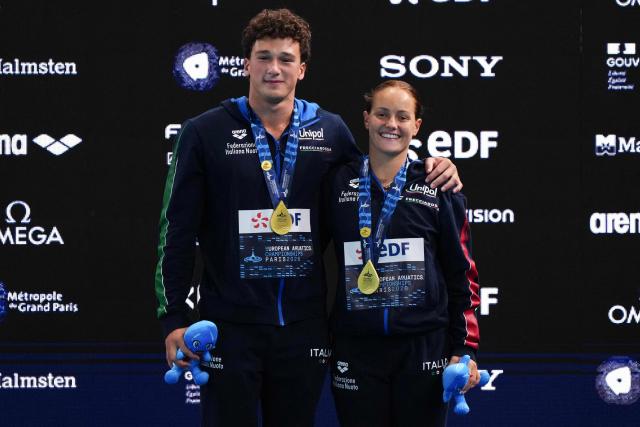 Winners, Italy's diver Matteo Santoro (L) and Italy's diver Chiara Pellacani celebrate on the podium after the mixed 3m synchro diving final event during the LEN European Aquatics Championships, at the Olympic Aquatics Centre in Saint-Denis, northeastern suburbs of Paris, on August 2, 2026. (Photo by Dimitar DILKOFF / AFP)