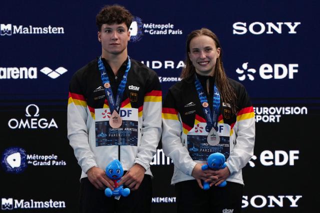 Third placed Germany's diver Luis Carlo Avila Sanchez and Germany's diver Lena Corona Hentschel celebrate on the podium after the mixed 3m synchro diving final event during the LEN European Aquatics Championships, at the Olympic Aquatics Centre in Saint-Denis, northeastern suburbs of Paris, on August 2, 2026. (Photo by Dimitar DILKOFF / AFP)