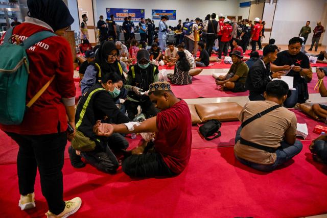 Survivors of the Mutiara Sentosa 2 ferry which caught fire in the waters off Madura island, East Java, on August 2, 2026, gather at Tanjung Perak port in Surabaya early on August 3, 2026. An Indonesian ferry caught fire at sea on Sunday, killing five people and leaving another 41 missing after some jumped overboard, search and rescue officials said. A total of 225 people on the vessel were rescued, said the regional Surabaya Search and Rescue Agency, which provided the latest figures in an afternoon update. (Photo by JUNI KRISWANTO / AFP)