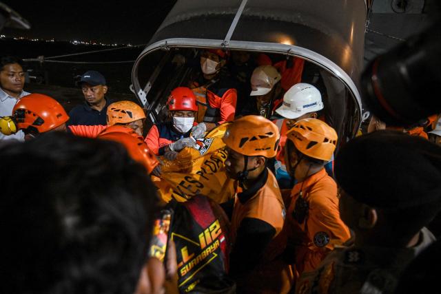 Rescue workers carry a body bag of one of the victims of the Mutiara Sentosa 2 ferry which caught fire in the waters off Madura island, East Java, on August 2, 2026, at Tanjung Perak port in Surabaya early on August 3, 2026. An Indonesian ferry caught fire at sea on Sunday, killing five people and leaving another 41 missing after some jumped overboard, search and rescue officials said. A total of 225 people on the vessel were rescued, said the regional Surabaya Search and Rescue Agency, which provided the latest figures in an afternoon update. (Photo by JUNI KRISWANTO / AFP)