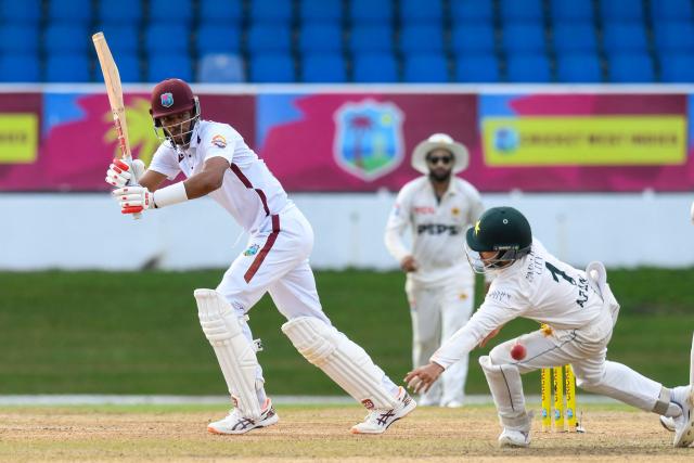 Roston Chase (L) of West Indies hits past Azan Awais (R) of Pakistan during the first day of the second Test match between West Indies and Pakistan at Queen's Park Oval in Port of Spain, Trinidad and Tobago, on August 2, 2026. (Photo by Randy Brooks / AFP)