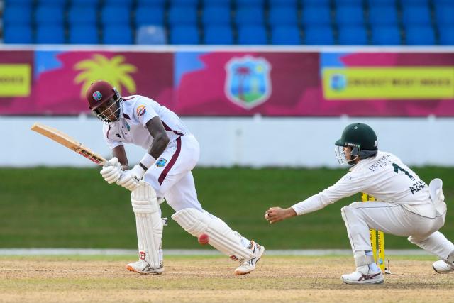 Roston Chase (L) of West Indies hits past Azan Awais (R) of Pakistan during the first day of the second Test match between West Indies and Pakistan at Queen's Park Oval in Port of Spain, Trinidad and Tobago, on August 2, 2026. (Photo by Randy Brooks / AFP)