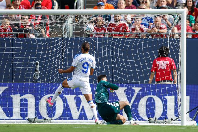 Leeds United's English striker #09 Dominic Calvert-Lewin scores against Liverpool's Georgian goalkeeper #25 Giorgi Mamardashvili during the second half of the pre-season friendly football match between Liverpool FC and Leeds United FC at Soldier Field in Chicago, Illinois on August 2, 2026. (Photo by KAMIL KRZACZYNSKI / AFP)