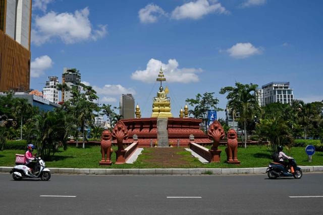 Motorists make their way past the Samdech Chuon Nath Statue in Phnom Penh on August 3, 2026. (Photo by TANG CHHIN Sothy / AFP)