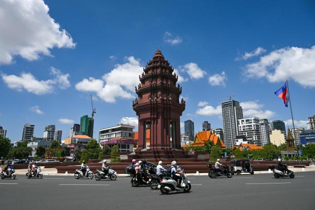 Motorists make their way past the Independence Monument in Phnom Penh on August 3, 2026. (Photo by TANG CHHIN Sothy / AFP)
