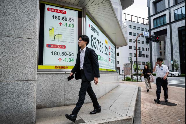 A man walks past a board showing the US dollar and Japanese yen exchange rate at a securities firm in Tokyo on August 3, 2026. (Photo by Andrew CABALLERO-REYNOLDS / AFP)