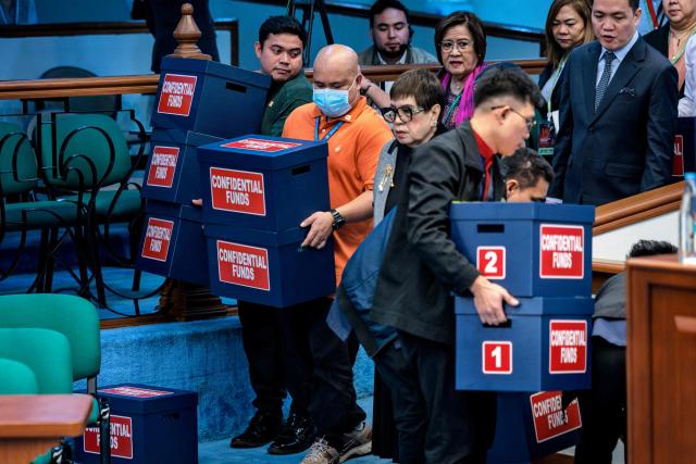 Workers carry boxes labelled "confidential funds" containing documents to be presented  during the impeachment trial of Philippine Vice President Sara Duterte at the Senate of the Philippines in Pasay, Metro Manila on August 3, 2026.  (Photo by Ezra Acayan / POOL / AFP)
