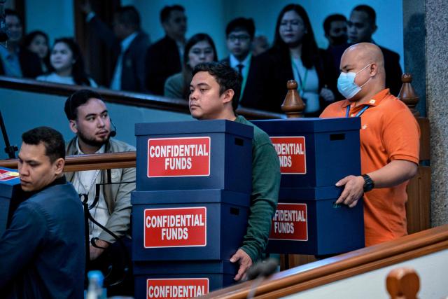 Workers carry boxes labelled "confidential funds" containing documents to be presented  during the impeachment trial of Philippine Vice President Sara Duterte at the Senate of the Philippines in Pasay, Metro Manila on August 3, 2026.  (Photo by Ezra Acayan / POOL / AFP)