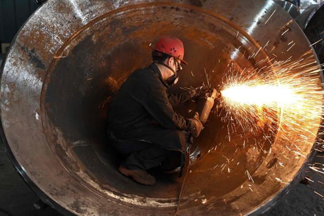 A worker grinds mining machinery products at the foundry workshop of Zhejiang Wujing Machinery Manufacturing in Wuyi, eastern China's Zhejiang province on August 3, 2026. (Photo by CN-STR / AFP) / China OUT