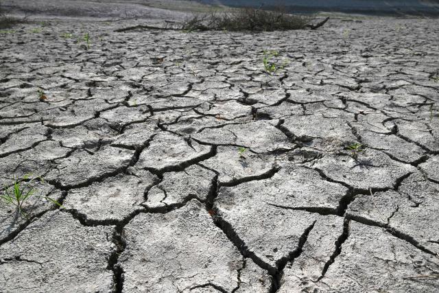 A general view shows the dried up bed of a reservoir in Miryang on August 3, 2026, as a scorching heat wave continues to grip South Korea. South Korea's weather agency issued a "severe heatwave warning" for Seoul on August 3, the first such advisory since introducing the designation this year to alert the public about extreme temperatures. (Photo by Jung Yeon-je / AFP)