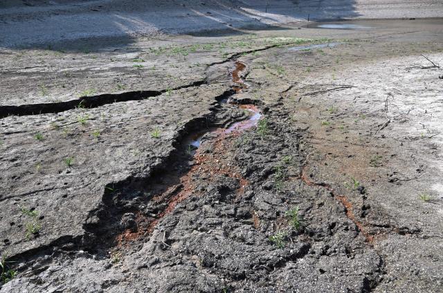 A general view shows the dried up bed of a reservoir in Miryang on August 3, 2026, as a scorching heat wave continues to grip South Korea. South Korea's weather agency issued a "severe heatwave warning" for Seoul on August 3, the first such advisory since introducing the designation this year to alert the public about extreme temperatures. (Photo by Jung Yeon-je / AFP)