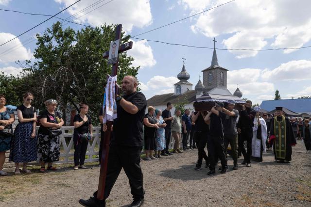 Pallbearers carry the coffin of a family member who was killed on July 30, 2026, during a funeral ceremony in Kryvyi Rig on August 3, 2026, amid the Russian invasion of Ukraine. A Ukrainian emergency services official had previously told AFP that the deaths of six people had been confirmed, while four others were presumed dead but had yet to be formally identified. (Photo by Serhii Okunev / AFP)