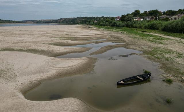 An aerial view shows a dried-out river bed of Danube in Rasova village August 3, 2026. Romanian army forces detonated an explosive load into the rock bed of Danube in Izvoarele village, kilometers away from Rasova, to help diverting a higher volume of water toward the cooling systems of the Cernavoda Nuclear Power Plant. Local authorities and plant engineers authorized the blasting operations to counteract critically low water levels caused by a prolonged summer heatwave, ensuring the continuous and safe operation of the facility's reactors. (Photo by Daniel MIHAILESCU / AFP)