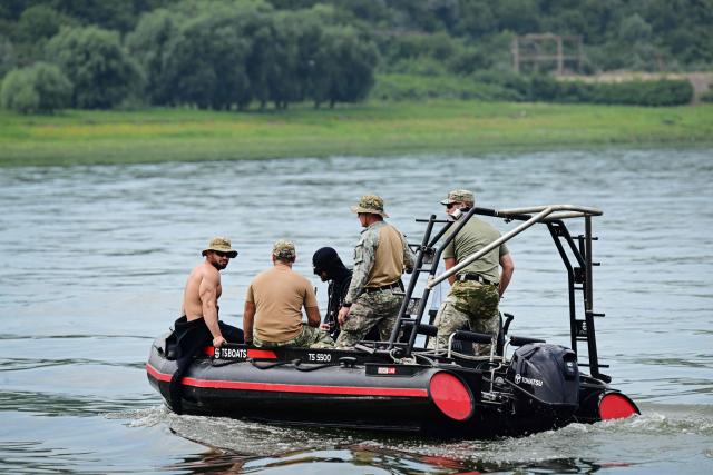 Romanian army divers observe the blast place after a controlled underwater explosion next Izvoarele village on August 3, 2026. Romanian army forces detonated an explosive load into the rock bed of Danube in Izvoarele village to help diverting a higher volume of water toward the cooling systems of the Cernavoda Nuclear Power Plant. Local authorities and plant engineers authorized the blasting operations to counteract critically low water levels caused by a prolonged summer heatwave, ensuring the continuous and safe operation of the facility's reactors. (Photo by Daniel MIHAILESCU / AFP)