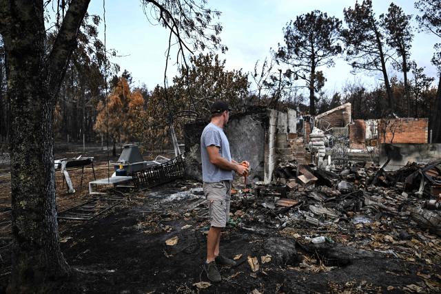 A resident looks over burnt debris in the garden of his completely destroyed house (not pictured) in Le Porge, southwestern France, on August 3, 2026, after authorities allowed residents to return to their homes. (Photo by Christophe ARCHAMBAULT / AFP)