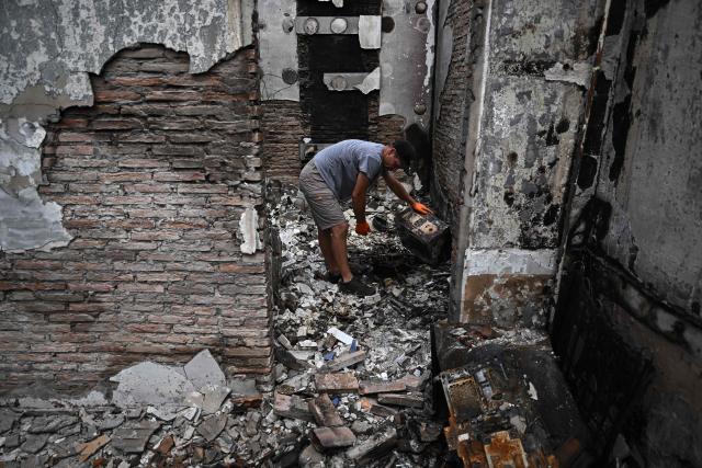 A resident inspects burnt equipment inside his completely burnt-out house in Le Porge, southwestern France, on August 3, 2026, after authorities allowed residents to return to their homes. (Photo by Christophe ARCHAMBAULT / AFP)