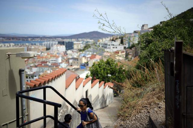 A woman climbs a path leading to the summit of "The Rock" in the British territoty of Gibraltar on August 3, 2026. A new era began between Spain and the tiny British territory of Gibraltar on July 15, 2026, as border checks that have long been a source of tension and frustration were finally lifted after the signing of a post-Brexit deal in Brussels between the UK, Spain, Gibraltar and the EU. (Photo by Henry NICHOLLS / AFP)