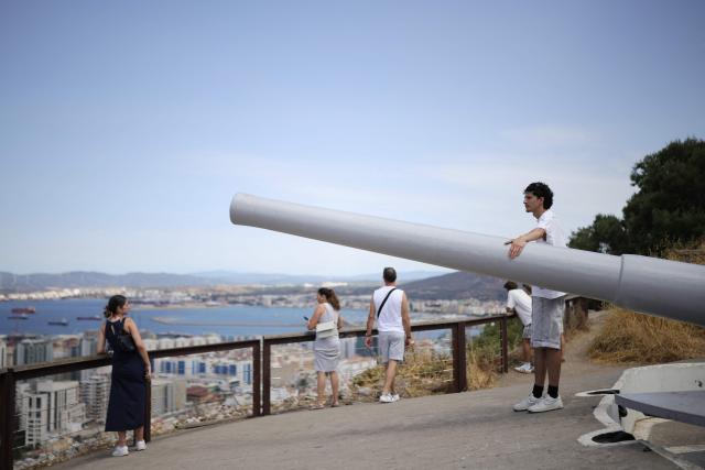 A man toches an old cannon, part of the artillery and fortifications of the Rock, in the British territoty of Gibraltar, on August 3, 2026. A new era began between Spain and the tiny British territory of Gibraltar on July 15, 2026, as border checks that have long been a source of tension and frustration were finally lifted after the signing of a post-Brexit deal in Brussels between the UK, Spain, Gibraltar and the EU. (Photo by Henry NICHOLLS / AFP)