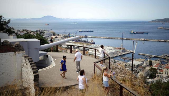 A group of people visit an old cannon, part of the artillery and fortifications of the Rock, in the British territoty of Gibraltar, on August 3, 2026. A new era began between Spain and the tiny British territory of Gibraltar on July 15, 2026, as border checks that have long been a source of tension and frustration were finally lifted after the signing of a post-Brexit deal in Brussels between the UK, Spain, Gibraltar and the EU. (Photo by Henry NICHOLLS / AFP)