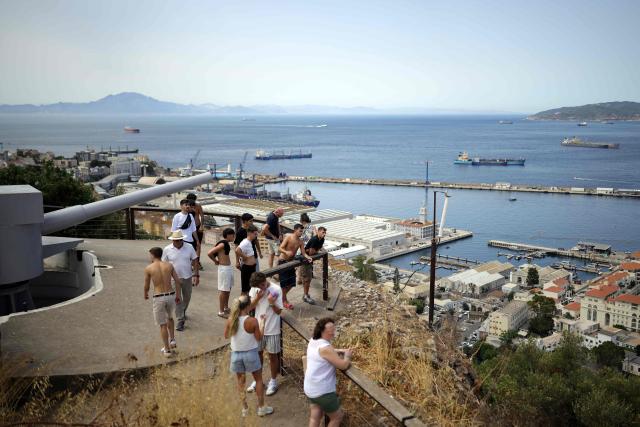 A group of people visit an old cannon, part of the artillery and fortifications of the Rock, in the British territoty of Gibraltar, on August 3, 2026. A new era began between Spain and the tiny British territory of Gibraltar on July 15, 2026, as border checks that have long been a source of tension and frustration were finally lifted after the signing of a post-Brexit deal in Brussels between the UK, Spain, Gibraltar and the EU. (Photo by Henry NICHOLLS / AFP)