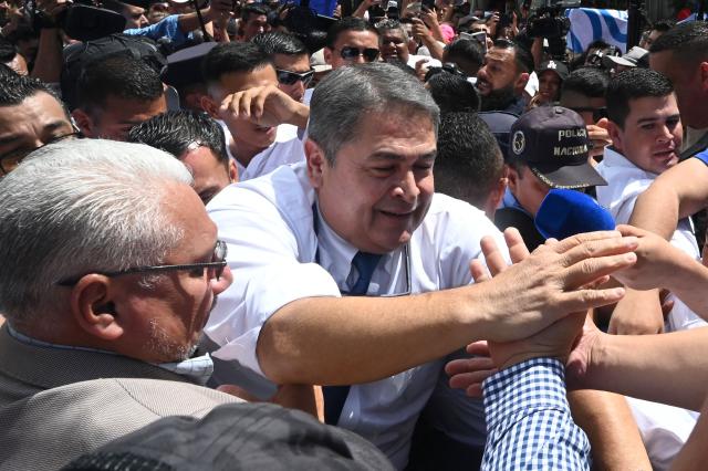 Former Honduras' President (2014-2022) Juan Orlando Hernandez greets supporters following a hearing at the Supreme Court of Justice in Tegucigalpa on August 3, 2026. Hernandez is accused of fraud and money-laundering charges, which he denies, claiming to be the continued victim of "persecution." A judge suspended an arrest warrant against him, as he agreed to appear voluntarily after US President Donald Trump pardoned him a 45-year prison sentence last year. (Photo by Orlando SIERRA / AFP)