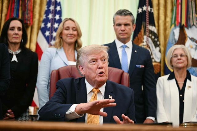 US President Donald Trump speaks after signing an executive order in the Oval Office of the White House in Washington, DC, on August 3, 2026. Also pictured, Defense Secretary Pete Hegseth (2R) and his wife Jennifer Hegseth (2L). (Photo by Jim WATSON / AFP)