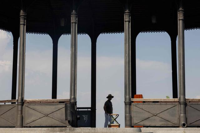 A man wearing a hat looks out over the city from the park in Kyiv on August 3, 2026, amid the Russian invasion of Ukraine. (Photo by Tetiana DZHAFAROVA / AFP)