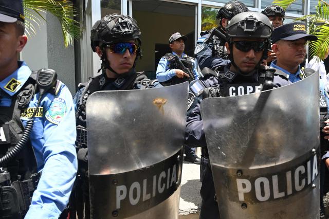 Riot police officers stand guard outside the Supreme Court of Justice during the initial court hearing of former Honduran President Juan Orlando Hernбndez (2014–2022) on corruption charges in Tegucigalpa on August 3, 2026. On August 3, a judge ruled that former Honduran President Juan Orlando Hernandez will be able to stand trial while free in a corruption case, which he is facing after U.S. President Donald Trump pardoned him for a drug trafficking conviction, the judiciary reported. (Photo by Orlando SIERRA / AFP)
