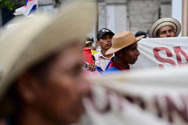 Farmers hold signs during a protest against the Rio Indio reservoir project in Panama City on August 3, 2026. The Rнo Indio Reservoir Project, promoted by the Panama Canal Authority (ACP), seeks to guarantee the supply of drinking water for more than two million people while safeguarding the Canal’s operations for the next 50 years. (Photo by MARTIN BERNETTI / AFP)