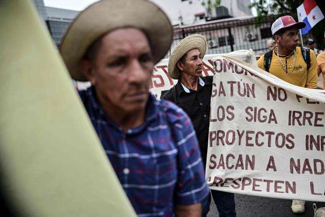 Farmers hold signs during a protest against the Rio Indio reservoir project in Panama City on August 3, 2026. The Rнo Indio Reservoir Project, promoted by the Panama Canal Authority (ACP), seeks to guarantee the supply of drinking water for more than two million people while safeguarding the Canal’s operations for the next 50 years. (Photo by MARTIN BERNETTI / AFP)