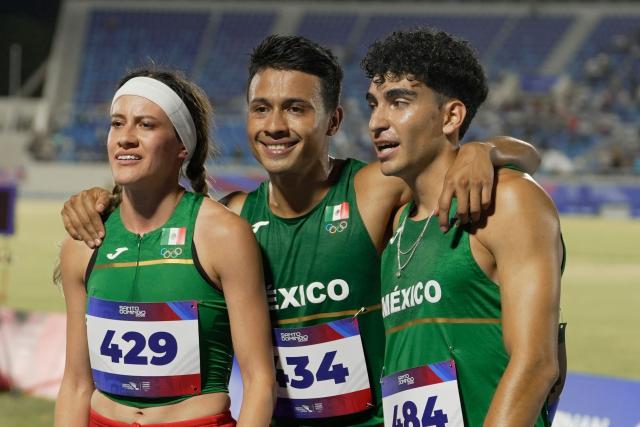 Mexico's Claudia Alvarado (L), Luis Aviles (C) and Pablo vargas pose after competing in the 4 x 400m relay mixed final event during the XXV Central American and Caribbean Games at the Felix Sanchez Olympic Stadium in Santo Domingo on August 3, 2026. (Photo by Francesco SPOTORNO / AFP)
