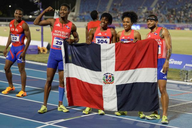 (2nd L to R) Dominican Republic's Christopher Melenciano, Marileidy Paulino, Anabel Medina and Erick Sanchez pose after winning the 4 x 400m relay mixed final event during the XXV Central American and Caribbean Games at the Felix Sanchez Olympic Stadium in Santo Domingo on August 3, 2026. (Photo by Francesco SPOTORNO / AFP)