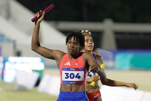 Dominican Republic's Marileydi Paulino (L) competes in the 4 x 400m relay mixed final event during the XXV Central American and Caribbean Games at the Felix Sanchez Olympic Stadium in Santo Domingo on August 3, 2026. (Photo by Francesco SPOTORNO / AFP)
