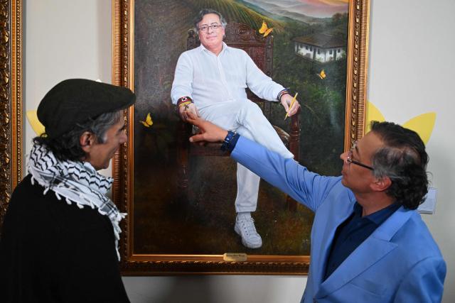 Colombian President Gustavo Petro (R) points at a portrait of himself painted by Colombian artist Jaime Rojas (L) during its unveiling at the Casa de Narino Presidential Palace in Bogota on August 3, 2026. (Photo by Raul ARBOLEDA / AFP)
