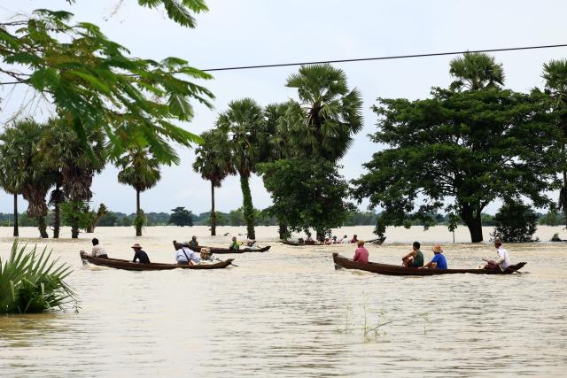 Local residents travel by boats through a flooded area in Lemyethna in Myanmar's Irrawaddy Delta region on August 3, 2026. (Photo by AFP)