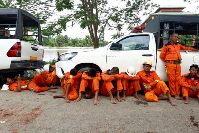 Rescue workers and firefighters take a rest by their vehicles during flood rescue operations in Lemyethna in Myanmar's Irrawaddy Delta region on August 3, 2026. (Photo by AFP)