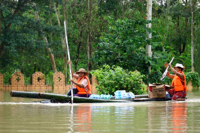Flood-affected residents ride a bamboo raft in Lemyethna in Myanmar's Irrawaddy Delta region on August 3, 2026. (Photo by AFP)