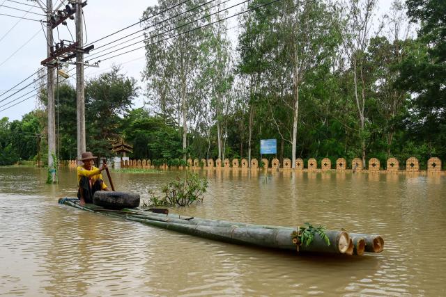A man resident rides a bamboo raft through flood waters in Lemyethna in Myanmar's Irrawaddy Delta region on August 3, 2026. (Photo by AFP)